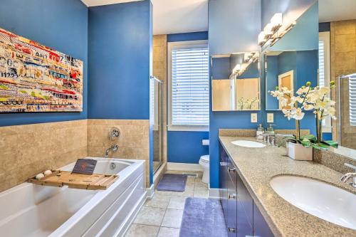 奧馬哈的住宿－Downtown Condo with Rooftop Patio and City Views!，浴室配有蓝色的墙壁、浴缸和水槽。