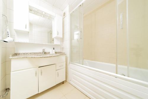 a white bathroom with a tub and a sink at Flat with Balcony and Shared Pool in Belek in Belek