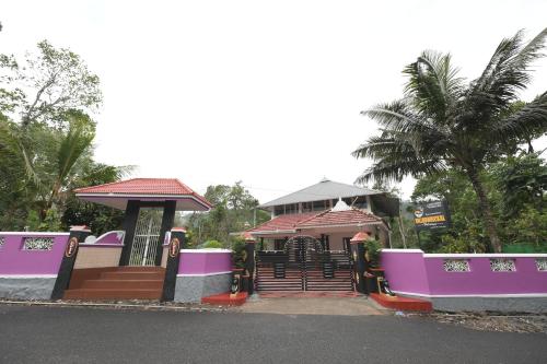 a building with purple and pink on a street at Villoonnickal Homestay in Munnar