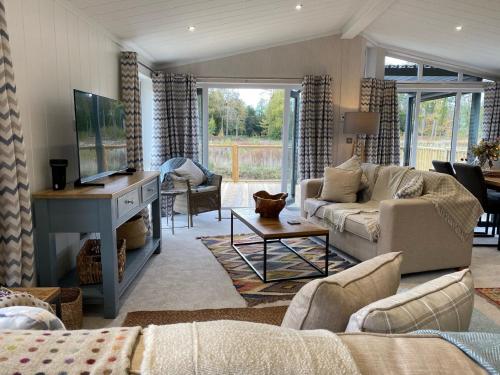 a living room with a couch and a tv at Holicarrs - Gingerlily in Riccall