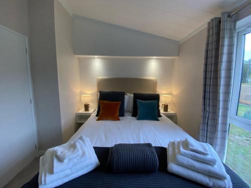 a bedroom with a bed with white sheets and pillows at Holicarrs - Gingerlily in Riccall
