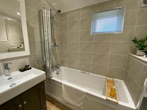 a bathroom with a tub and a sink and a shower at Holicarrs - Gingerlily in Riccall