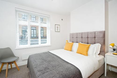 a bedroom with a bed and a chair and a window at F2 Greek Street by City Living London in London