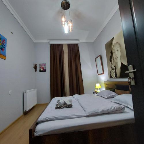 a bedroom with a bed with a picture on the wall at Guesthouse different in Tbilisi City