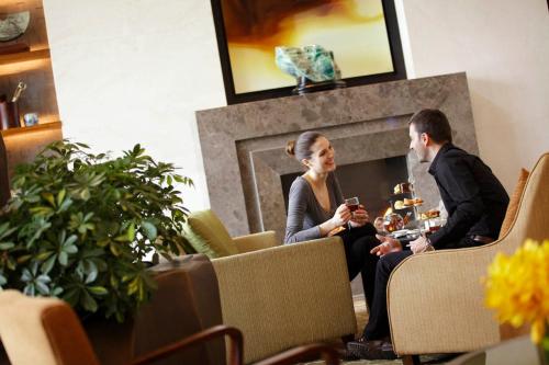 a man and woman sitting in chairs in front of a fireplace at InterContinental Suzhou Hotel by IHG in Suzhou