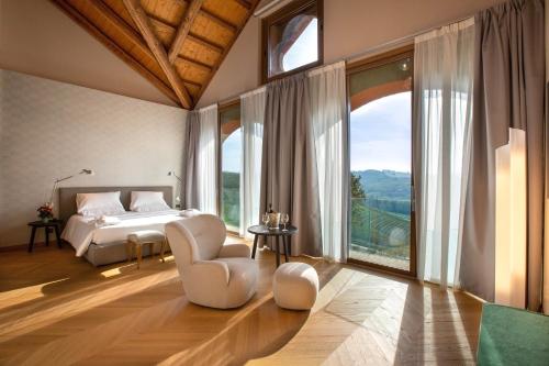 a bedroom with a bed and a large window at Villaggio Narrante - Cascina Galarej in Sorano