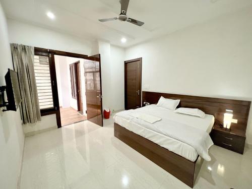 1 dormitorio con 1 cama y TV en Radha Krishna Bhawan, Homestay en Vrindāvan