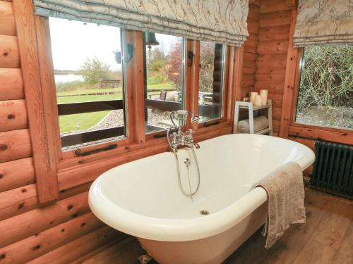 uma banheira num quarto de madeira com uma janela em Whitemoor Lodge em Barnoldswick