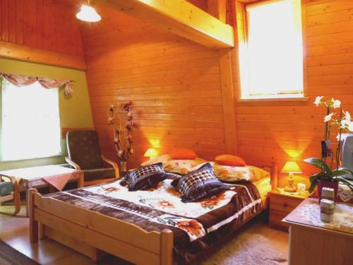 a bedroom with a large bed in a wooden room at Willa Rosa in Szczyrk