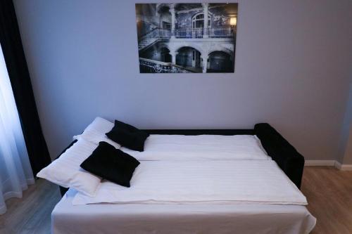 a bed with black and white pillows in a room at Heart of Niš in Niš