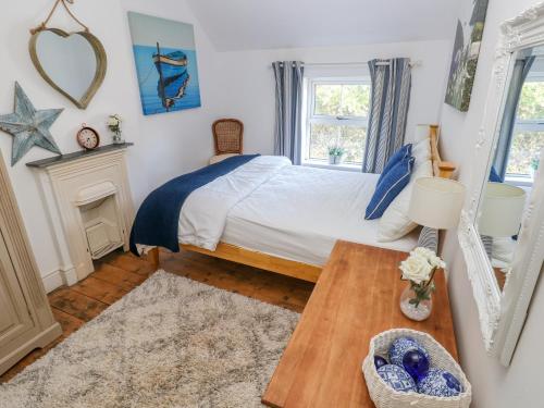 a bedroom with a bed and a table at Min Y Ffordd in Goodwick