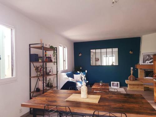 un salon avec une table et un mur bleu dans l'établissement Superbe maison au calme Avignon, à Avignon
