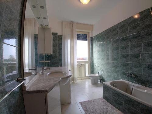 bagno con lavandino, vasca e servizi igienici di Luminoso Appartamento con Balcone a Veduggio con Colzano
