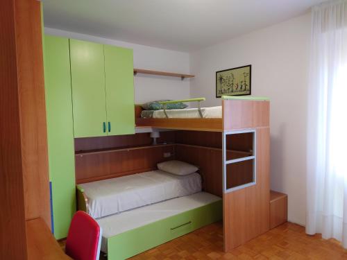una camera con 2 letti a castello e armadi verdi di Luminoso Appartamento con Balcone a Veduggio con Colzano