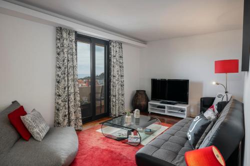 a living room with a couch and a television at Casa Sta Clara by An Island Apart in Funchal