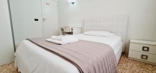een slaapkamer met een bed met twee handdoeken erop bij Locazione Turistica Gioia in Padua