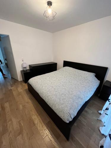 a bedroom with a large bed and a wooden floor at Superbe appartement de 51m2 à 10mn de Paris in Boulogne-Billancourt