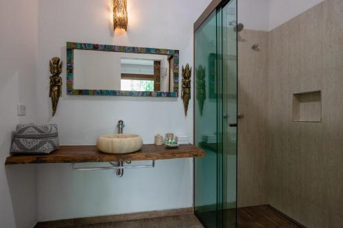 a bathroom with a sink and a glass shower at Hotel Vila Kebaya in Ilhabela