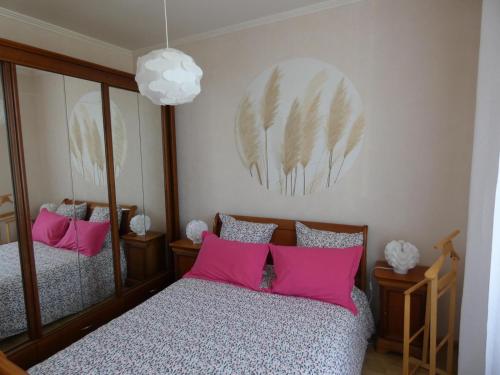 1 dormitorio con 2 camas y almohadas rosas en gite de l épinette, en Commentry