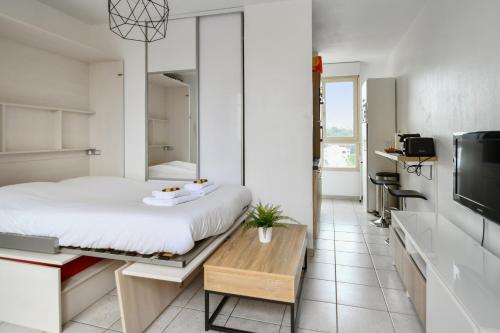 une chambre avec un lit, une table et une télévision dans l'établissement Studio Doris - Welkeys, à Montpellier