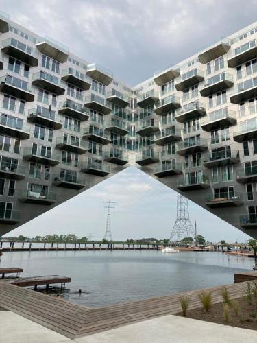 a large apartment building with a bridge over a body of water at The Water Studio in Amsterdam
