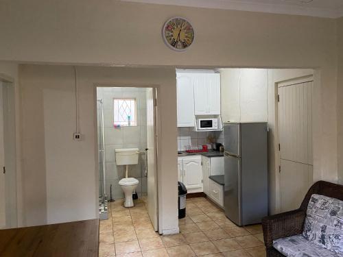 a small kitchen with a refrigerator and a sink at Dickens Garden Flat in Empangeni