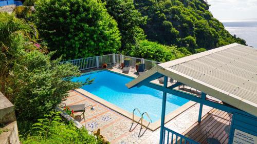 an overhead view of a swimming pool with a roof at Résidence La Clément in Les Anses-dʼArlets