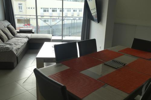 a living room with a table and a couch at Appartement L'Entonnoir in Berck-sur-Mer