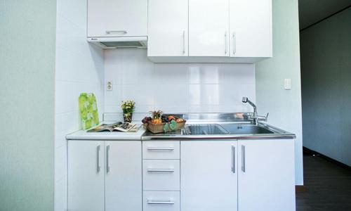 a kitchen with white cabinets and a sink at Chalet Resort in Pyeongchang 