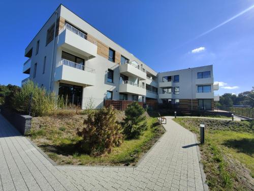 an apartment building with a pathway in front of it at M&K Apartament Szafirowy - Wyspa Sobieszewska in Gdańsk