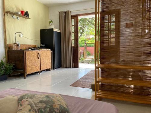 uma sala de estar com uma cozinha e um quarto com uma porta em SURF PARADISE apartamentos em Pinheira