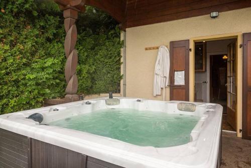 a large bath tub with green water in it at Chalet traditionnel avec jacuzzi extérieur in Bex