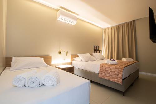 Ipioca的住宿－Ipioca Beach Resort，酒店客房设有两张床和电视。