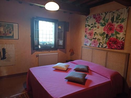 1 dormitorio con 1 cama rosa y 2 almohadas en Paradiso, en Marsciano