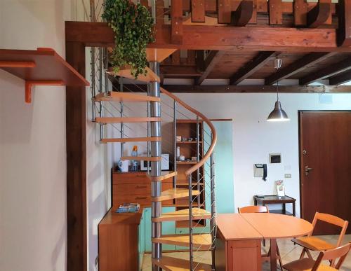 レッチェにあるMonolocale Del Casaleのテーブル付きの客室内の木製の螺旋階段