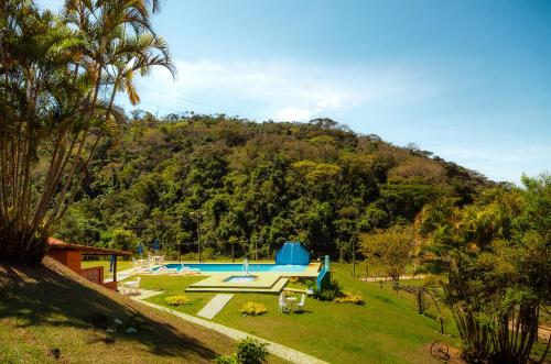 um quintal com uma piscina e uma montanha em ECO RESORT FASCINAÇÃO em Miguel Pereira