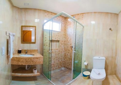 a bathroom with a glass shower and a toilet at Pousada Mar de Luna in Penha
