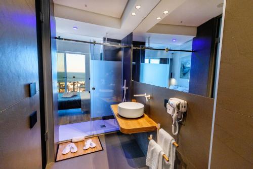 a bathroom with a sink and a large mirror at Hibrido Boutique Hotel & Spa in Sciacca