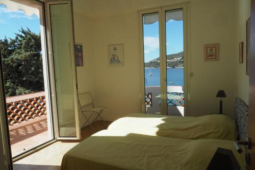 a bedroom with a bed and a balcony with a view at Villa la Felicite in Saint-Jean-Cap-Ferrat