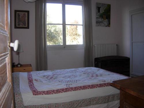 a bedroom with a bed and a window at maison florentine in La Gaude