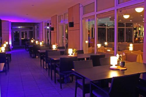バート・フィルベルにあるシティ ホテル フランクフルト バート フィルベルのテーブル、椅子、照明付きのレストラン