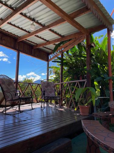 a wooden deck with chairs and a pergola at Dreams Lodge Orosi in Cartago