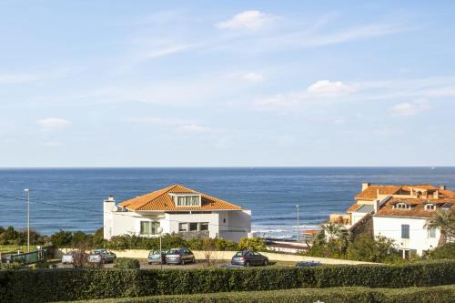 una casa con coches aparcados frente al océano en Large studio with ocean view 5 min to Anglet beach - Welkeys, en Anglet