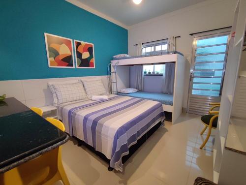a bedroom with a bunk bed and a blue wall at Residencial Sol Nascente in Aracaju