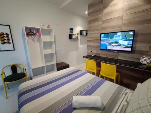 a bedroom with a bed and a flat screen tv at Residencial Sol Nascente in Aracaju