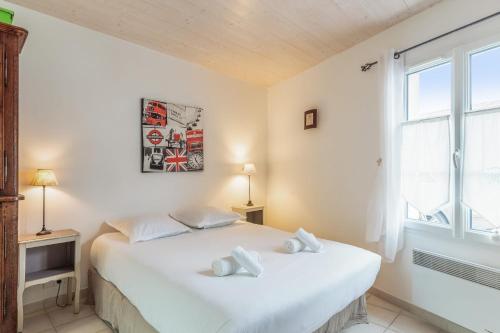 een slaapkamer met een wit bed en een raam bij Nice studio with veranda nearby the beach in La Flotte - Welkeys in La Flotte