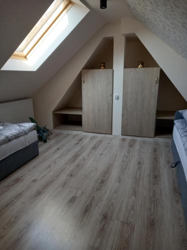 a attic room with two beds and a skylight at Apartament 6 osobowy Pasternik in Małe Ciche