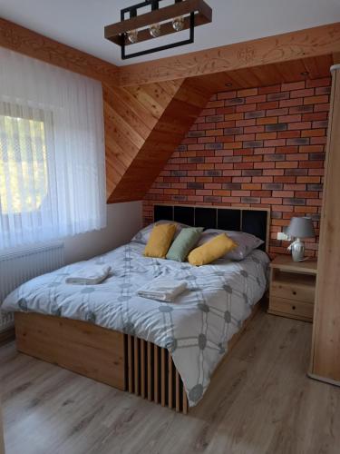 1 dormitorio con cama y pared de ladrillo en Apartament 6 osobowy Pasternik en Ciche Małe