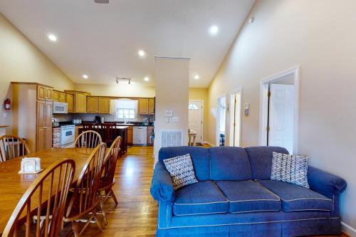 a living room with a blue couch and a table at Orr at Waterways in Huddleston