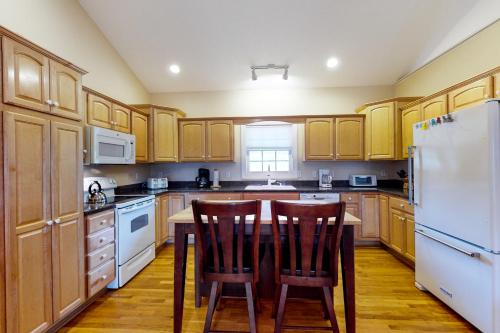 a kitchen with wooden cabinets and a table and chairs at Orr at Waterways in Huddleston